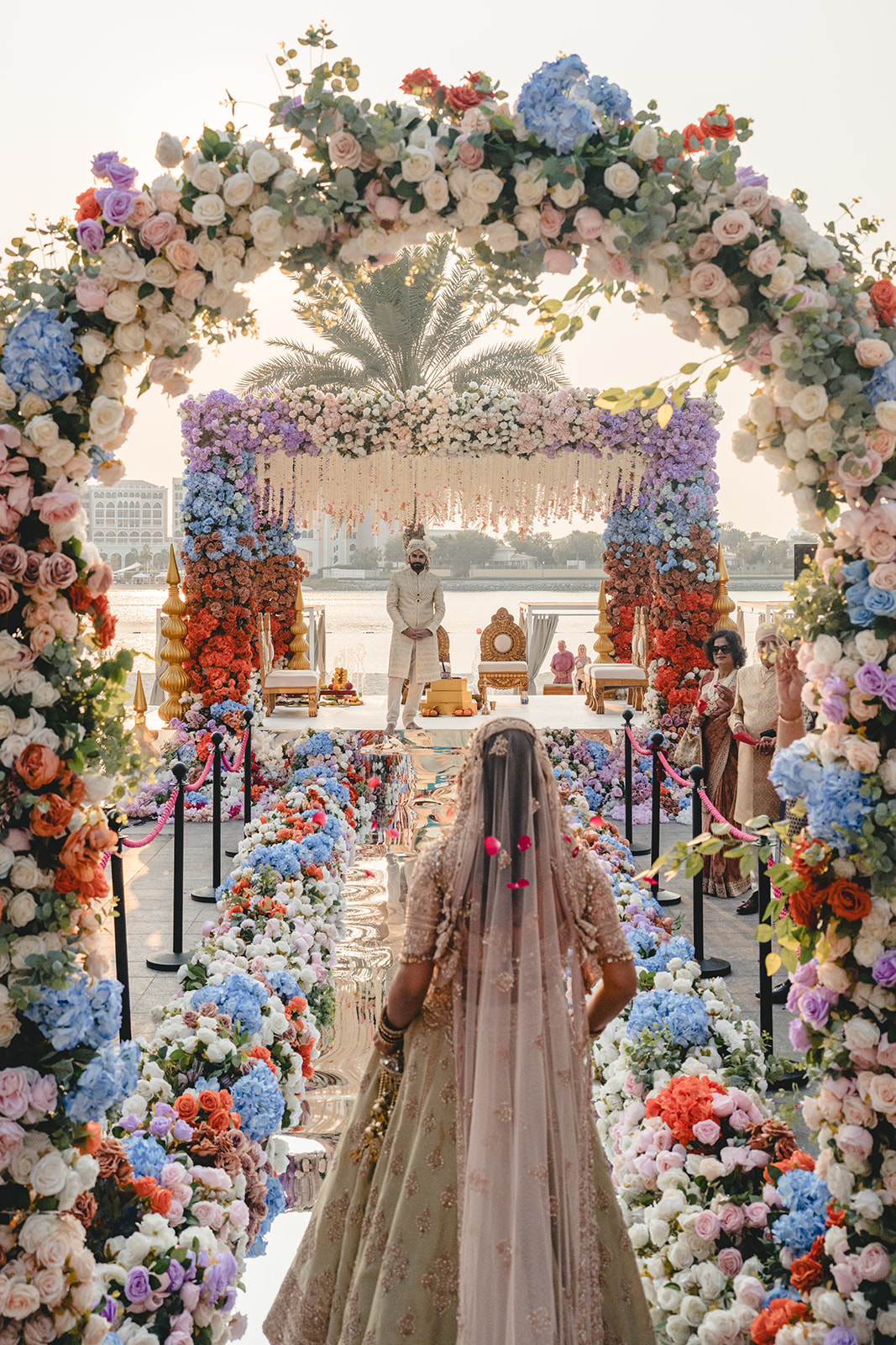 Braut Sophie schreitet die Stufen zum Mandap hinab während ihrer indischen Hochzeit im Fairmont Abu Dhabi