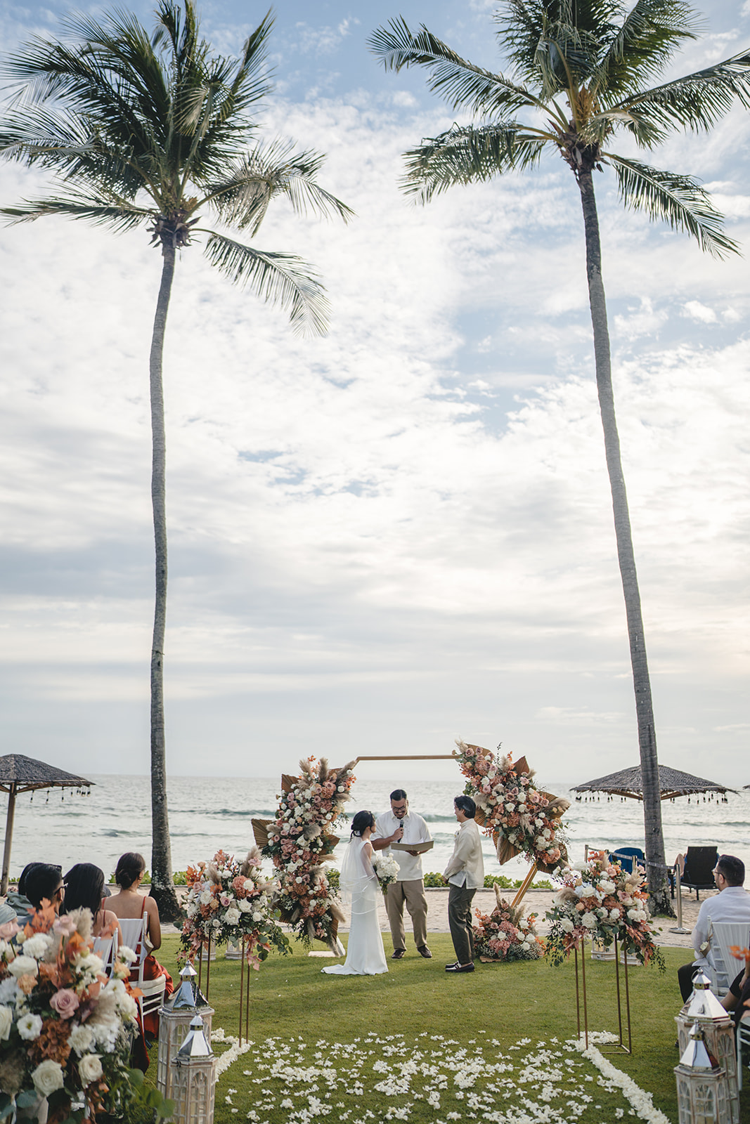Apple Grace and Andrew during their ceremony on the beach in Phuket, surrounded by palms