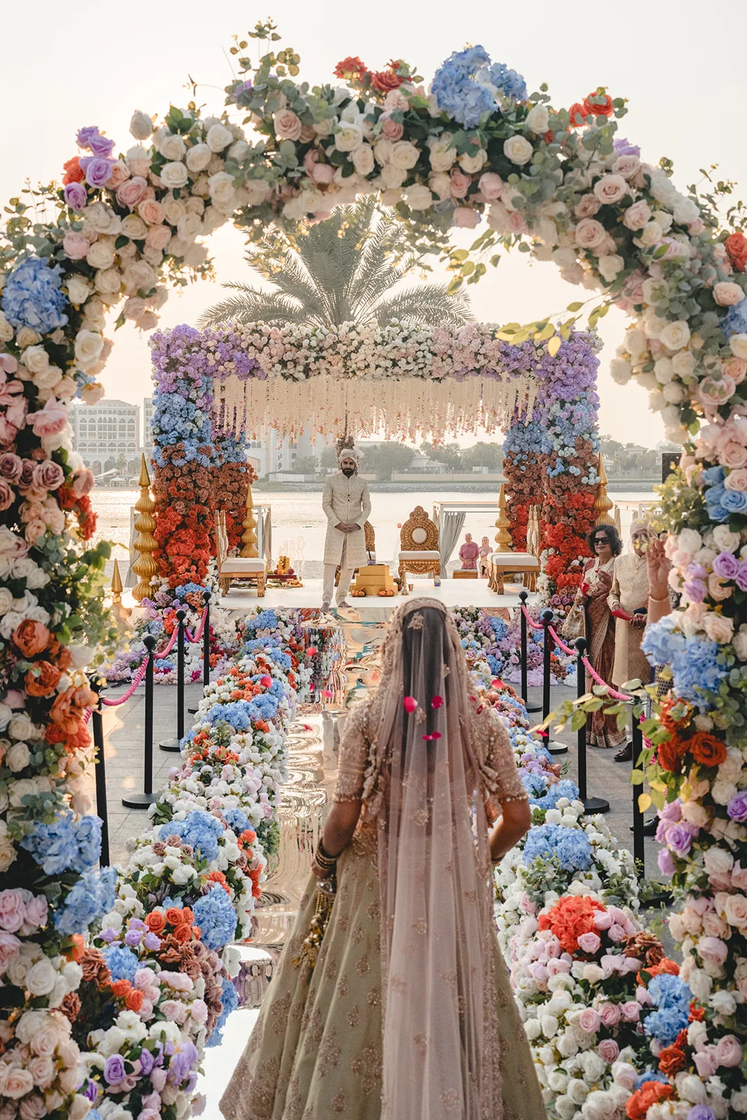 Braut Simran schreitet die Stufen zum Mandap hinab während ihrer indischen Hochzeit im Fairmont Abu Dhabi