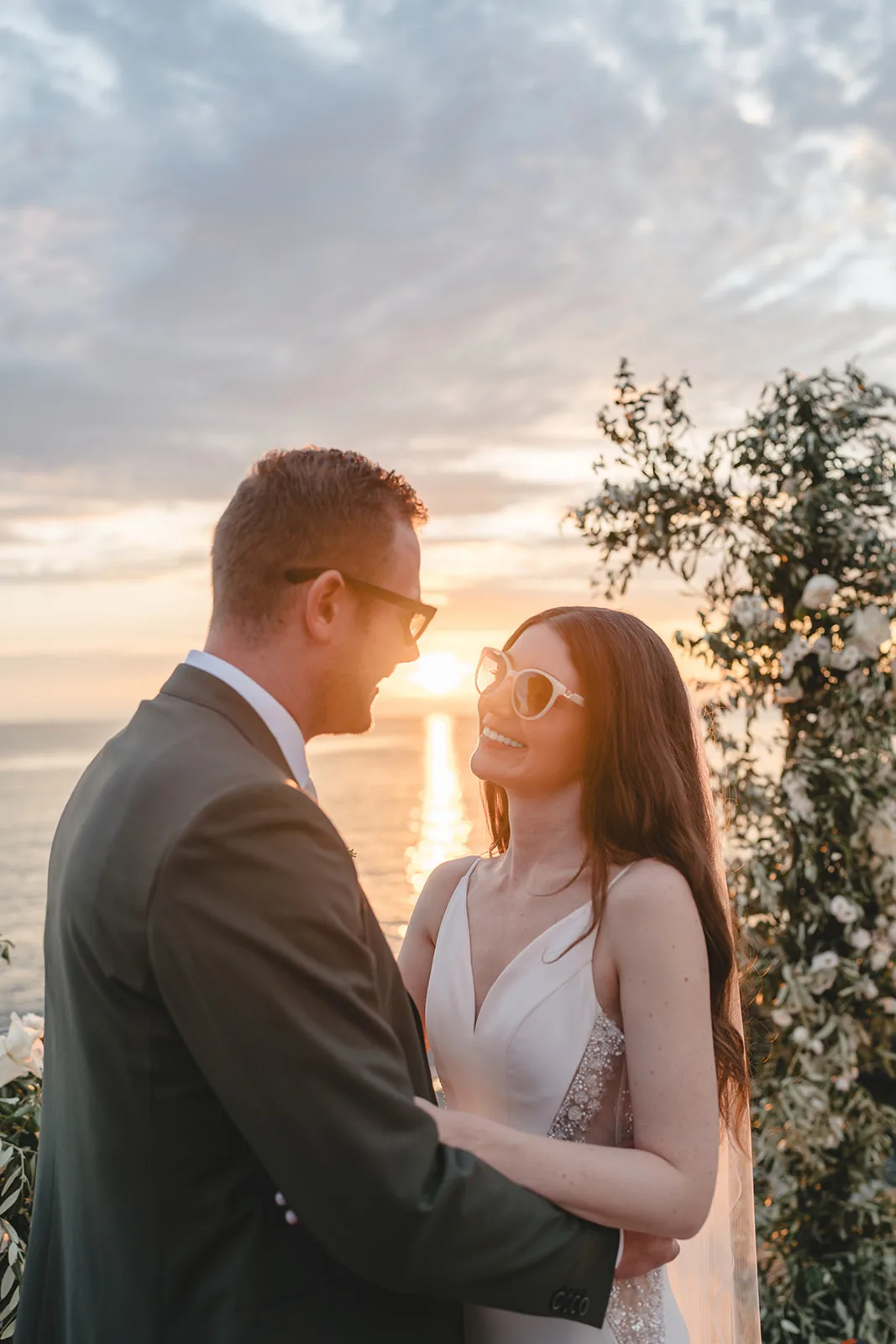 Jennise and Florian facing each other in the evening light, sparklers behind them