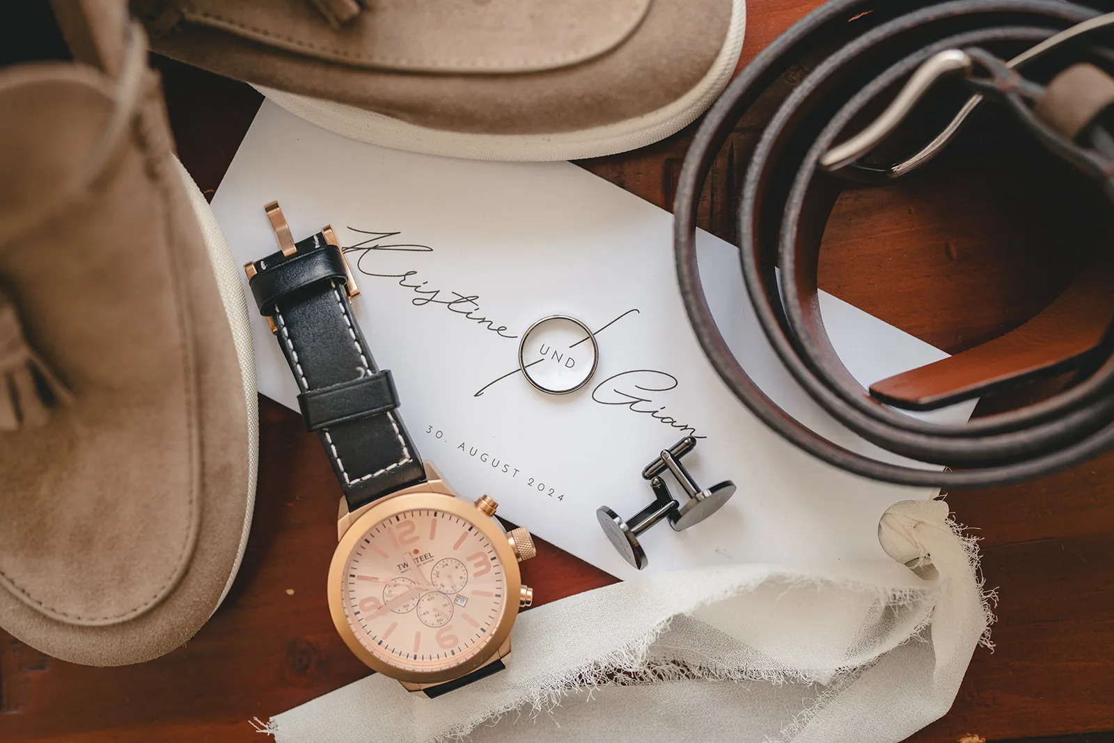 Ringe, Uhr und Accessoires des Bräutigams auf der Einladungskarte — Hochzeit im Schloss Halbturn, Burgenland