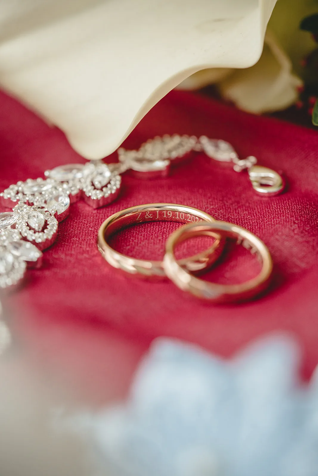 Gravierte Eheringe und Brautschmuck auf rotem Samt — Hochzeit in Maria am Gestade, Wien